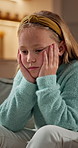 Sad, thinking and child with depression in home, loneliness or remember trauma memory with boredom. Unhappy girl, kid and anxiety in living room, reflection or deep thoughts with flashback on sofa