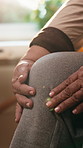 Hands, knee pain and senior person in house with arthritis inflammation, gout or osteoporosis. Injury, sore leg and woman with chronic condition, fibromyalgia and massage for joint ache in retirement