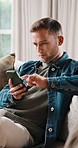 Phone, relax and man in home for online post, social media or scroll forum for internet search. Mobile, chill and male person on living room sofa for chat app, text message or reading ebook on web