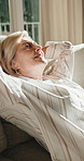 Old woman, stretching and relax at house with smile, peace and comfortable for calm morning. Happy, senior person and rest in home with reflection, unwind and stress relief on couch for weekend break