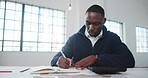 Architect, notebook and man in office with writing, design plan and draft of renovation project. Review, black person and engineer with notes, progress checklist and strategy brief for remodeling.