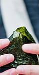Eating, outdoor and hands of man with onigiri for travel, holiday or trip with lunch, snack or meal. Local food, seaweed and Japanese person with rice ball for health on adventure, break or vacation.