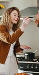 Couple, feeding and kitchen with spaghetti in home for hospitality, cooking or taste recipe. Happy, woman and high five with man for meal serving, food preparation or smile for ingredients in house