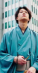 Buildings, walking and yakata with Asian man in city for commute, journey or traditional clothes. Culture, thinking and travel with Japanese person outdoor in urban town for break, trip or vision