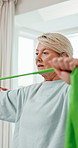 Physio, resistance band and mature woman with exercise for rehabilitation, healing or fitness. Healthcare professional, patient and consultation with stretching, laugh and wellness at clinic