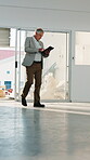 Building, inspector and man with tablet, walking and safety check on construction site or evaluation. Real estate, property manager and mature person with technology, online and quality assurance