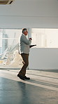Building, quality assurance and man with tablet, walking or plan for renovation on construction site. Real estate, property manager and mature person with technology, pointing and safety check