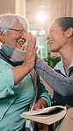 Caregiver, high five and senior woman in home with book, word search and encourage for crossword. Smile, nurse or old person in lounge with sudoku, answer success and achievement for puzzle activity