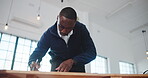 Architecture, office and black man at desk for writing, drawing and blueprint for building design. Creative, low angle and person with layout, ideas and planning for renovation, remodeling and sketch