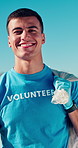 Trash bag, man and face of volunteer on beach for recycle, clean or waste management. Garbage, smile and portrait of ngo worker by ocean for dirt collection, reduce pollution or community service.