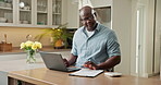 Laptop, home and black man with finance for budget planning, mortgage expenses or bills in kitchen. Male person, documents or checking invoice with computer for financial assessment or tax in house