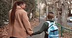 Mom, walk and holding hands outdoor with school child, connection and support for education goals. Back, happy black woman and son in neighborhood with safety, learning skills and commute to academy.