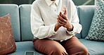 Hands, woman and massage at house with wrist pain, inflammation and symptoms for carpal tunnel. Female person, discomfort and cramp on couch with muscle stiffness, rheumatic disease and pinched nerve