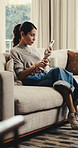 Texting, phone and woman on sofa with coffee, online communication and scroll on social media. Smile, digital or mature person in house with warm drink, message notification or connection on chat app