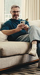 Laugh, phone and man on couch with scroll, online communication and comic post on social media. Happy, digital and mature person in house with browse, funny text and meme reaction on chat app.