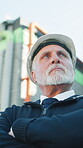 Construction, thinking or man outdoor with arms crossed, review or reflection in building evaluation. Industrial, below or mature supervisor with ppe, project perspective or operation plan on site.