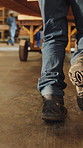 Carpentry, walking and legs of man in workshop to transport wood, material and lumber inventory. Carpenter, woodworking and person with trolley for furniture, timber production and manufacturing