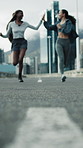 Active, friends and running in city with high five, exercise success and accomplishment for wellness. Low angle, blur and people in urban town for workout, fitness goals and celebration with space.