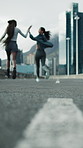 Fitness, people and running in city with high five, success and support for cardio exercise outdoor. Low angle, blur and friends downtown for workout, wellness and celebration with space from back.