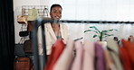 Rail, tablet and woman in clothing store for small business, online shop management and stock. Happy, black person and technology in boutique for retail, fashion industry and trade or app for startup