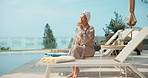 Pool, drink and woman on chair at hotel for vacation, holiday and weekend getaway for break. Hospitality, towel and person with mimosa, juice or cocktail for relax, travel and tourism at resort