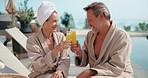Toast, drink and couple by pool at hotel for vacation, holiday and bonding on weekend getaway. Marriage, happy and man with woman cheers with mimosa, alcohol and juice for love on break and travel