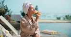 Pool, cocktail and woman at hotel for vacation, holiday and weekend getaway for me time or break. Hospitality, towel and person with mimosa, juice or drink for relax, travel and tourism at resort