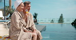 Hotel, happy and couple by pool with drink for vacation, holiday and bonding on weekend getaway. Marriage, relax and man with woman with juice, alcohol and talking for love, connection and travel