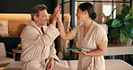 Spa, tablet and man with masseuse high five for service, treatment and thank you for pamper. Hospitality, resort and person with massage therapist on tech for wellness review, success and therapy