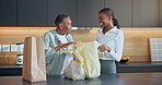 Family, shopping bags and women with grocery in home, hug and bonding with senior mother in kitchen. Black people, happiness and elderly parent with daughter, embrace and laughing together in house