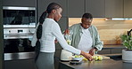 Blender, fruit and senior mother with adult daughter for wellness, discussion or natural ingredients. Black women, elderly mom and smoothie recipe in kitchen with healthy diet, help and talk in home.