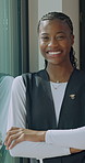 Caregiver, face and happy woman with arms crossed in nursing home, healthcare or career development. Nurse, portrait and black person with smile for health services, laugh and pride for medical job