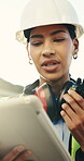 Woman, engineer and radio at worksite with tablet, building instruction and problem solving. Low angle, supervisor and outdoor with tech for operations management, contact and project update in app