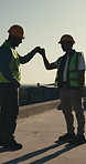 Construction worker, fist bump and men with smile, outdoor and agreement for renovation on rooftop. Builder, celebration and happy people with achievement, talk and collaboration on building site