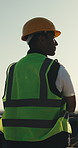 Construction, thinking and back of man outdoor for evaluation, planning and building project. Architecture, morning and worker with reflection for remodeling, property development and crossed arms