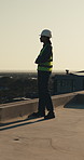 Thinking, construction and woman on rooftop for building project, renovation and inspection. Morning, city and person with ppe, idea and helmet for safety compliance, remodeling and quality assurance