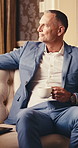 Businessman, waiting and drink with coffee in hotel lounge for work trip or career opportunity. Man, employee or traveler contemplating with cup on sofa for business travel, accommodation or vision