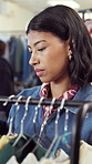 Shopping, woman and search clothes rack for fashion, garment size or deal hunting in thrift store. Rail, shopper or browse for clearance sale, limited stock or specific outfit choice in retail outlet