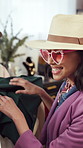 Smile, woman and shopping at store for clothes, choice and clearance sale for thrift fashion. Excited, female person and customer in boutique, vintage outfit and bargain price of designer collection