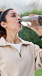 Break, water and woman outdoor with fitness, training pause or recovery with wellness activity. Hydration, cool down or mature person with bottle, workout rest or refreshing stop in backyard exercise