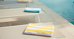 Towel, chair and swimming pool for spa relaxation, holiday getaway or outdoor travel in resort. Empty, fabric or cloth in luxury retreat for calm vacation, summer break or accommodation by poolside