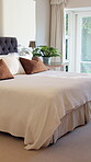 Empty, room and bed in motel, hospitality and furniture with decor, real estate and interior design. Luxury, accommodation and cozy blanket in bedroom, comfort and tidy hotel or travel destination
