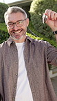 Face, keys and mature man at property for pride for investment, home ownership and loan approval. Happy, person or buyer smile for sale, lease or rent house from seller or landlord for relocation 