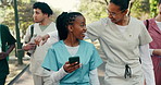 Friends, walk and medical students at university with phone, hug and conversation with social media. Happy, people and break outdoor in park with tech, internet and college for healthcare education.