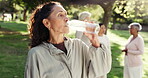 Rest, water or woman in park with fitness class, workout break or recovery in wellness activity. Hydration, cool down or mature person with bottle, training pause or refreshing stop in group session.