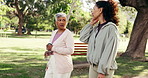 Mature, friends and walking in park for fitness, conversation or catch up in nature for health. Cardio, wellness and female people talking outdoor, water bottle and serious discussion with exercise