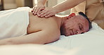 Spa, sleep, and man on bed for back massage with physical therapy, relax or hospitality at resort. Hotel, luxury masseuse and mature person for stress relief, muscle reflexology or holistic detox