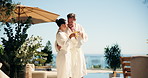 Couple, spa and cheers at resort with tea, romantic vacation and bonding outdoor on anniversary trip. Happy, married mature people and toast at wellness retreat with drink, love and relax on holiday.
