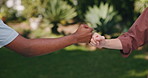 Friends, hands and fist bump outdoor with support, bonding together and appreciation for community. People, secret handshake and friendship in garden with respect, connection and special greeting.