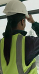 Helmet, back and woman on construction site for safety, infrastructure and property inspection. Architecture, civil engineering and window view with PPE equipment, renovation and remodeling project